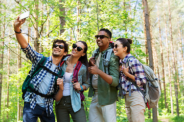 Image showing friends with backpacks hiking and taking selfie