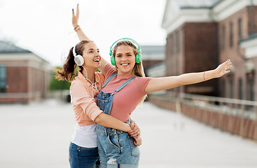 Image showing teenage girls or friends in headphones in city