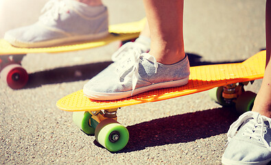 Image showing close up of female feet riding short skateboard