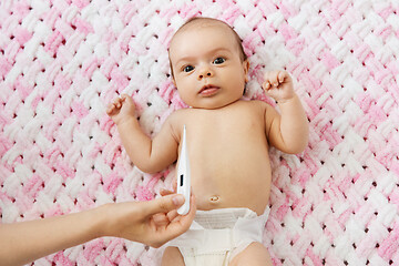 Image showing mother\'s hand measuring temperature of baby girl