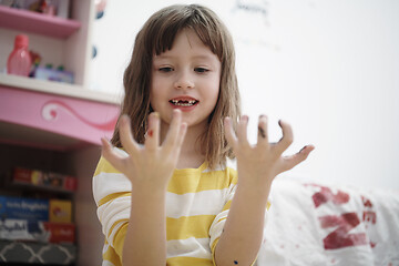 Image showing cute little girl at home painting with hands