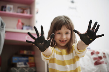 Image showing cute little girl at home painting with hands