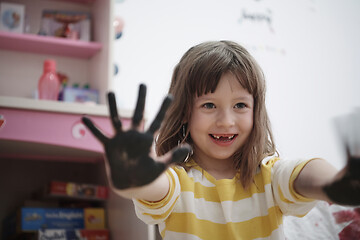 Image showing cute little girl at home painting with hands