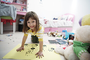 Image showing cute little girl at home painting with hands