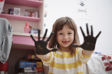 Image showing cute little girl at home painting with hands