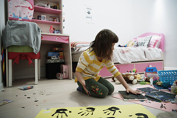 Image showing cute little girl at home painting with hands