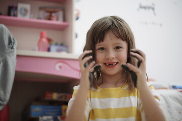 Image showing cute little girl at home painting with hands