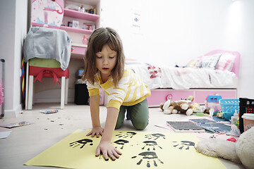 Image showing cute little girl at home painting with hands