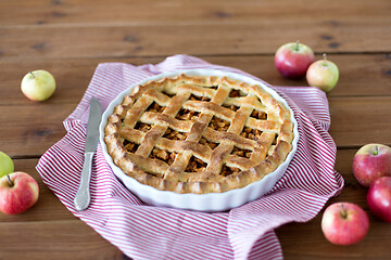 Image showing close up of apple pie in baking mold and knife