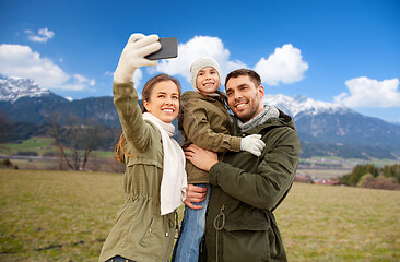 Image showing family taking selfie by smartphone over alps