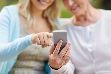 Image showing daughter and senior mother with smartphone at park