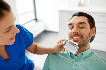 Image showing dentist choosing tooth color for patient at clinic