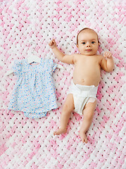 Image showing baby girl in diaper lying with dress on blanket