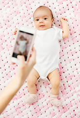 Image showing sweet baby girl being photographed by smartphone