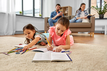 Image showing happy sisters drawing and doing homework at home