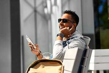 Image showing man with earphones and smartphone on city street