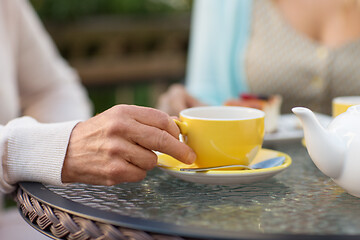 Image showing hand of senior woman drinking tea at outdoor cafe