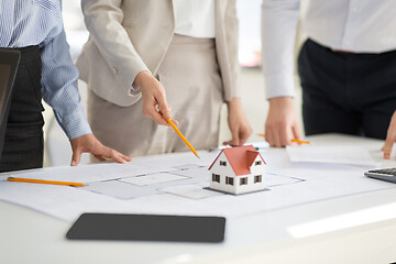 Image showing close up of architects with blueprint at office