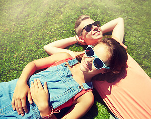 Image showing happy teenage couple lying on grass at summer