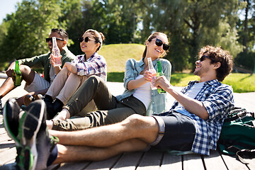 Image showing friends drinking beer and cider in summer park