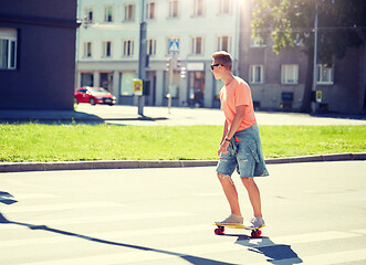 Image showing teenage boy on skateboard crossing city crosswalk