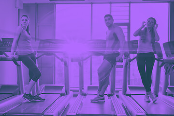 Image showing Group of people running on treadmills