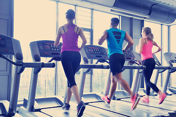 Image showing Group of people running on treadmills