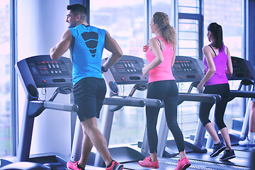 Image showing Group of people running on treadmills