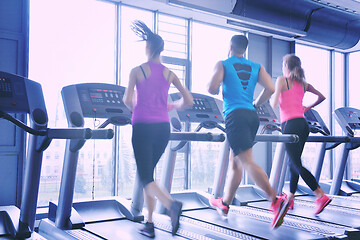 Image showing Group of people running on treadmills