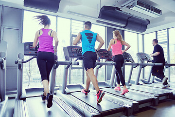 Image showing Group of people running on treadmills