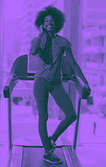 Image showing afro american woman running on a treadmill