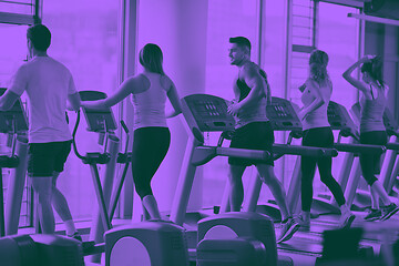 Image showing Group of people running on treadmills