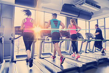 Image showing Group of people running on treadmills