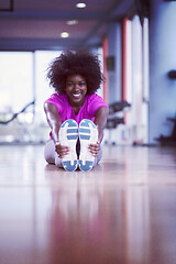 Image showing woman in a gym stretching and warming up before workout