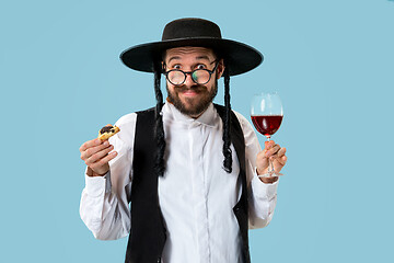 Image showing The young orthodox Jewish man with black hat with Hamantaschen cookies for Jewish festival of Purim