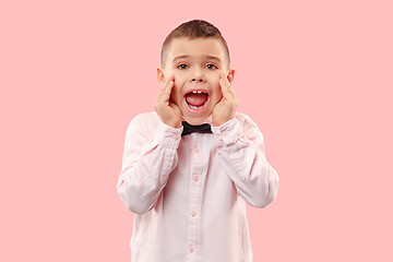 Image showing Isolated on pink young casual boy shouting at studio