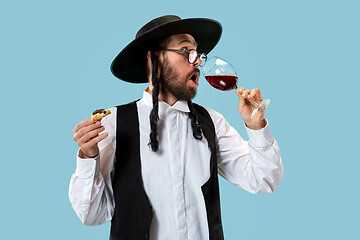 Image showing The young orthodox Jewish man with black hat with Hamantaschen cookies for Jewish festival of Purim