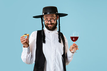 Image showing The young orthodox Jewish man with black hat with Hamantaschen cookies for Jewish festival of Purim