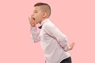 Image showing Isolated on pink young casual boy shouting at studio