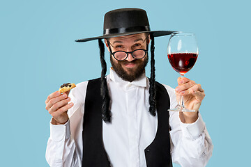 Image showing The young orthodox Jewish man with black hat with Hamantaschen cookies for Jewish festival of Purim