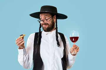 Image showing The young orthodox Jewish man with black hat with Hamantaschen cookies for Jewish festival of Purim