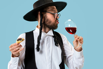 Image showing The young orthodox Jewish man with black hat with Hamantaschen cookies for Jewish festival of Purim