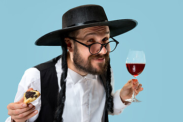 Image showing The young orthodox Jewish man with black hat with Hamantaschen cookies for Jewish festival of Purim