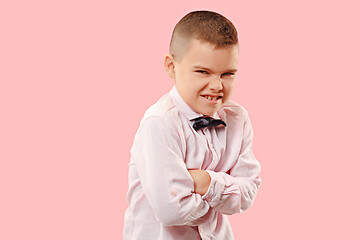 Image showing The young emotional angry teen boy on pink studio background