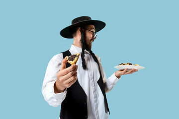 Image showing The young orthodox Jewish man with black hat with Hamantaschen cookies for Jewish festival of Purim