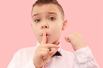 Image showing The teen boy whispering a secret behind her hand over pink background