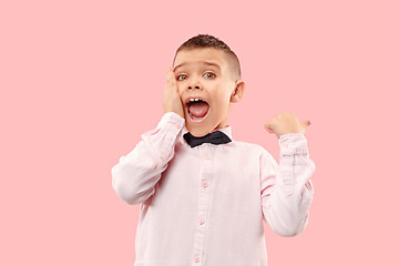 Image showing The young attractive teen boy looking suprised isolated on pink