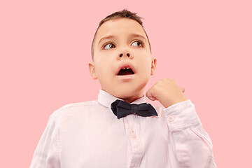 Image showing The young attractive teen boy looking suprised isolated on pink