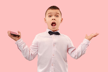 Image showing The young attractive teen boy looking suprised isolated on pink