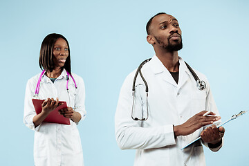 Image showing The female and male happy afro american doctors on blue background